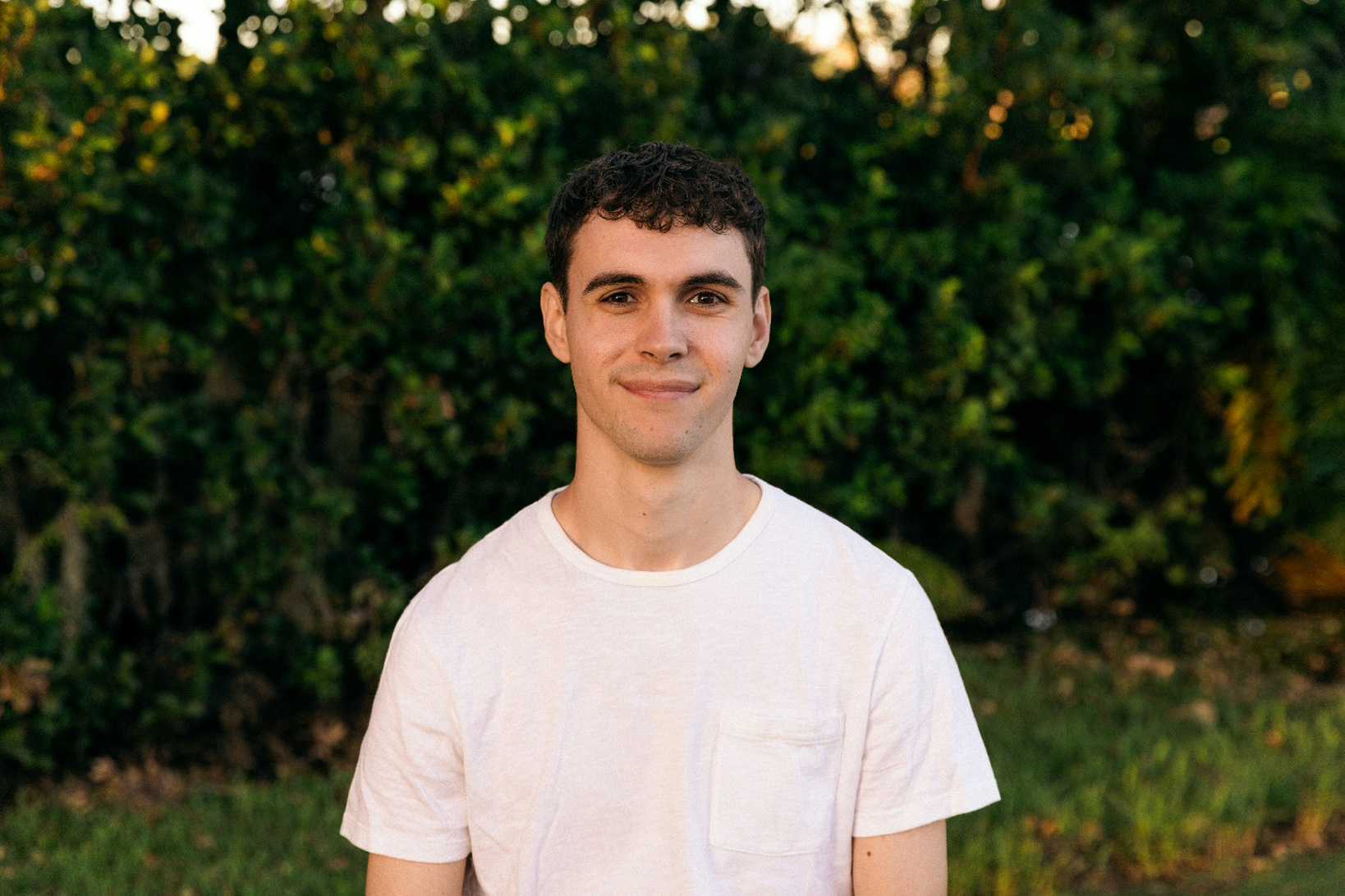 Ben Hayden outdoors in front of green trees
